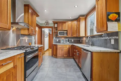 a kitchen with stainless steel appliances granite countertop a stove a sink and a refrigerator