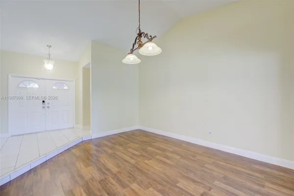 a view of a room with wooden floor and white walls