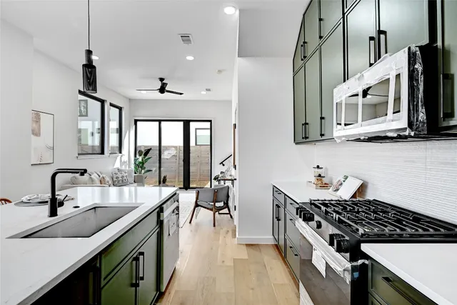 a kitchen with stainless steel appliances a sink stove and cabinets