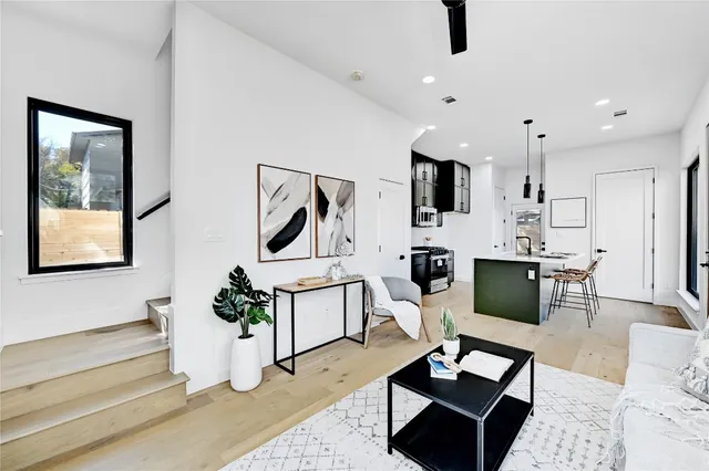 a living room with furniture a flat screen tv and kitchen view