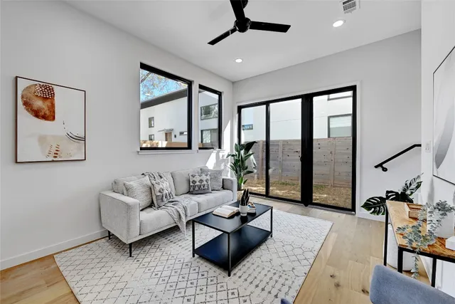a living room with furniture and floor to ceiling windows