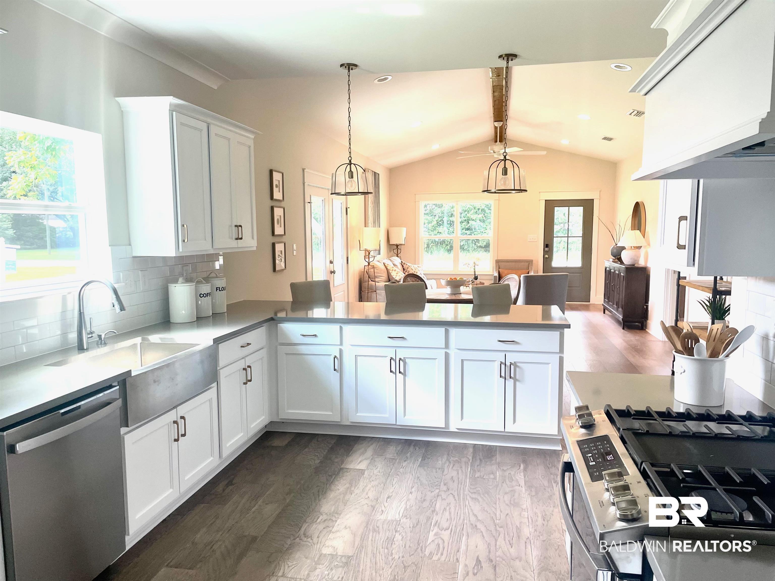 14710 Camelia Street Magnolia Springs, AL 36555 - Photo 6 of 23 Kitchen featuring dishwasher, tasteful backsplash, wood-type flooring, kitchen peninsula, and hanging light fixtures