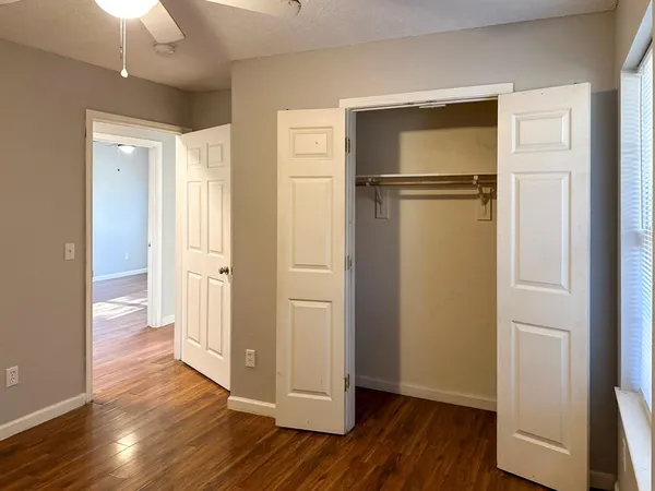 an empty room with wooden floor and windows