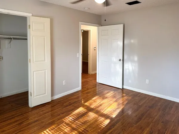 a view of empty room with window and chandelier fan