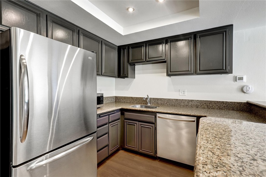 3000 Associated Road, Unit 60 Fullerton, CA 92835 - Photo 1 of 51 a kitchen with stainless steel appliances granite countertop a refrigerator a sink and white cabinets