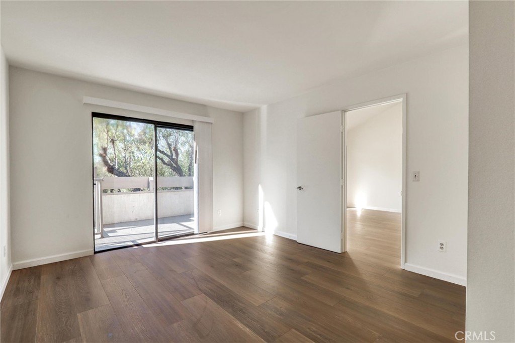 3000 Associated Road, Unit 60 Fullerton, CA 92835 - Photo 13 of 51 an empty room with wooden floor and windows