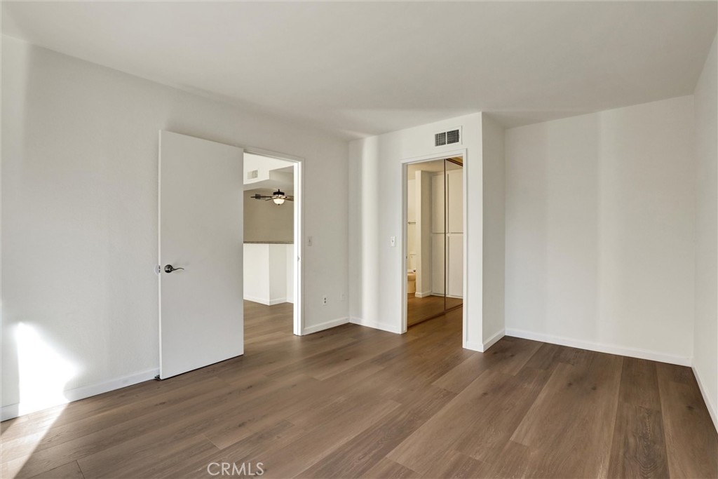 3000 Associated Road, Unit 60 Fullerton, CA 92835 - Photo 15 of 51 a view of an empty room with wooden floor and a window