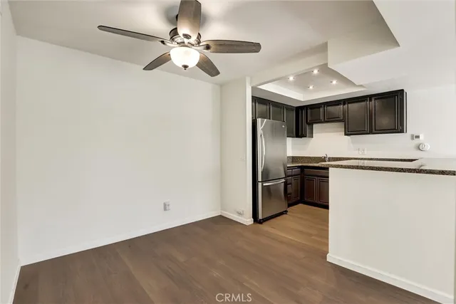 a kitchen with stainless steel appliances wooden floors and white cabinets