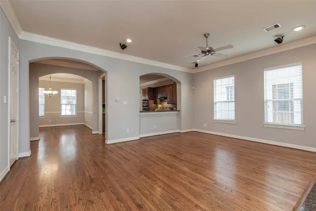 a view of an empty room with window and wooden floor