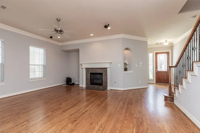 a view of a livingroom with wooden floor fireplace and windows