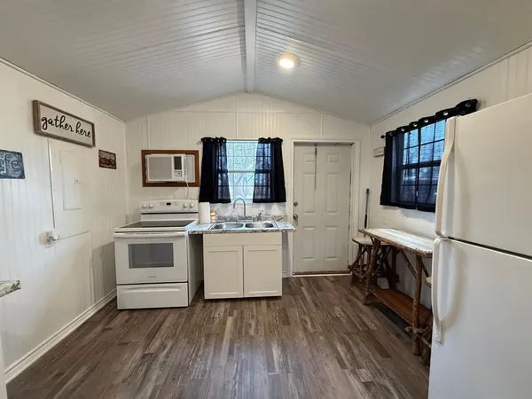 a kitchen with a refrigerator and white cabinets