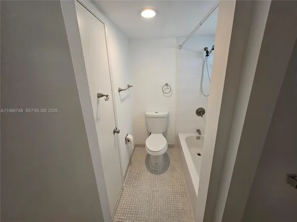 a bathroom with a granite countertop shower and a toilet