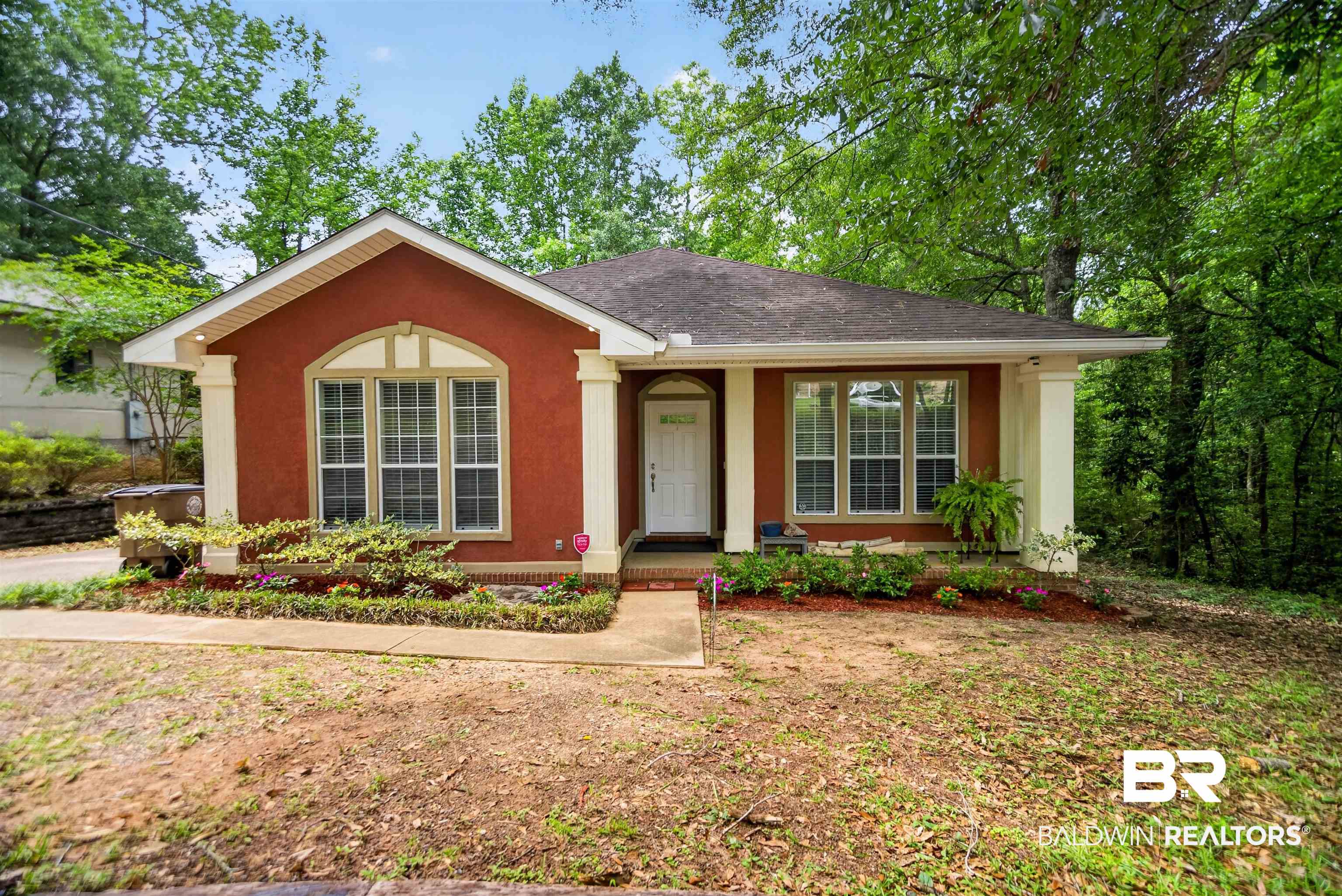 5913 Antoine Road Mobile, AL 36693 - Photo 32 of 33 Stucco exterior with a peaked roofline, decorative arched window, covered entryway, and front landscaping