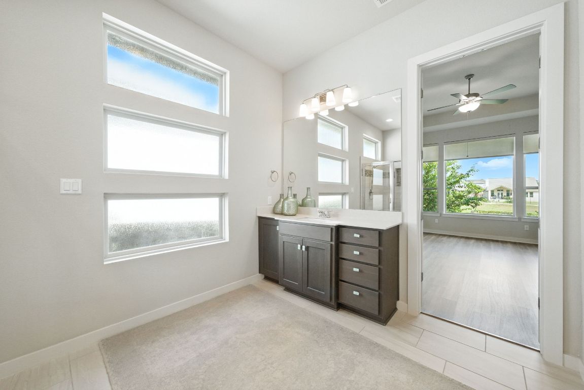 437 Pienza Drive Georgetown, TX 78628 - Photo 22 of 32 a spacious bathroom with a granite countertop sink mirror and a bathtub