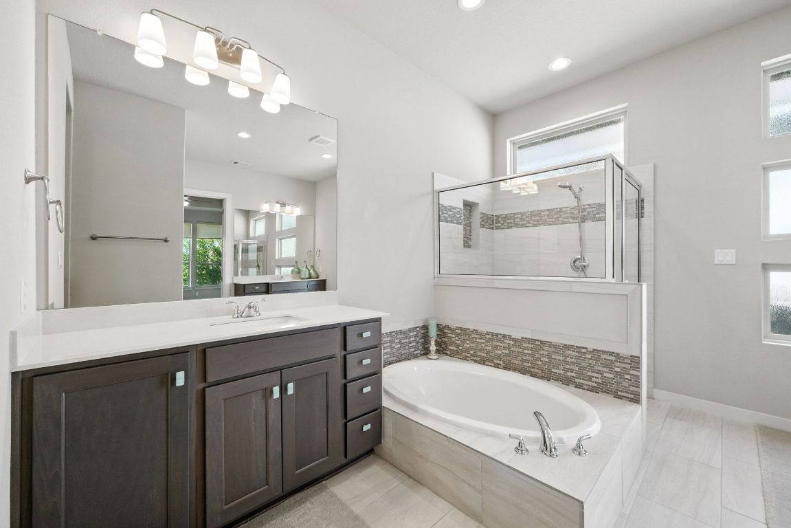 437 Pienza Drive Georgetown, TX 78628 - Photo 23 of 32 a bathroom with a tub a sink double vanity and a mirror