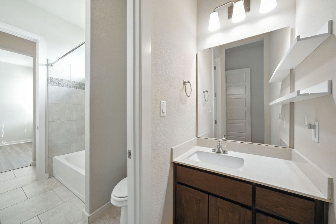 437 Pienza Drive Georgetown, TX 78628 - Photo 9 of 32 a bathroom with a sink a toilet and shower