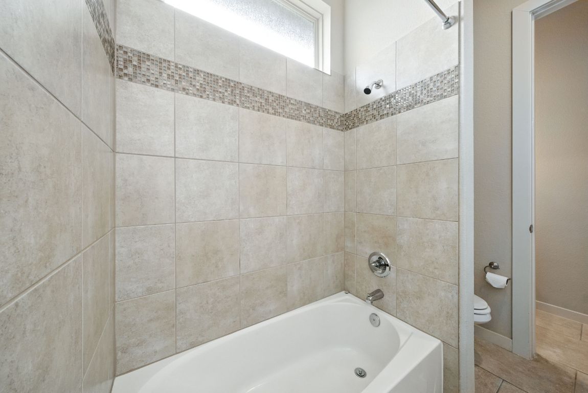 437 Pienza Drive Georgetown, TX 78628 - Photo 10 of 32 a bathroom with a bathtub and a shower
