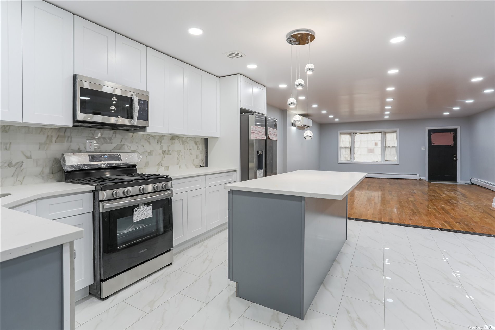 a kitchen with stainless steel appliances kitchen island granite countertop a sink and a microwave