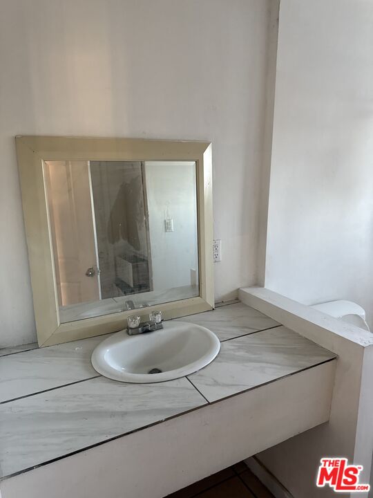 4908 Fort Tejon Road Palmdale, CA 93552 - Photo 17 of 21 a bathroom with a sink and a mirror