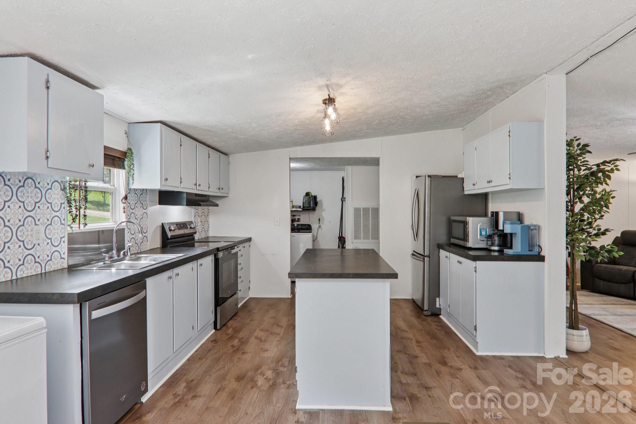 4 Sweet Birch Drive Alexander, NC 28701 - Photo 22 of 48 a kitchen with stainless steel appliances kitchen island granite countertop a stove top oven a sink a counter top space and cabinets
