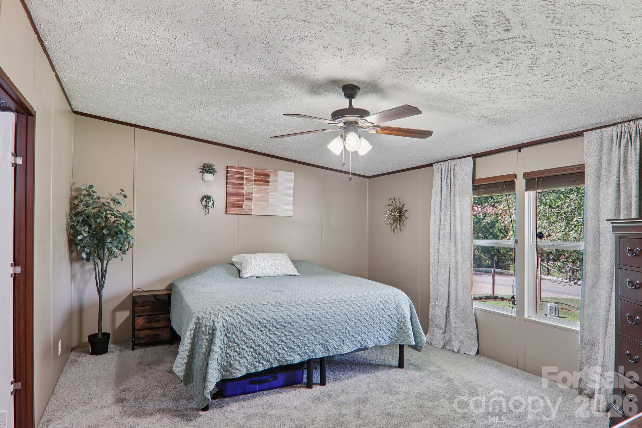 4 Sweet Birch Drive Alexander, NC 28701 - Photo 31 of 48 a bedroom with a large bed and a chandelier