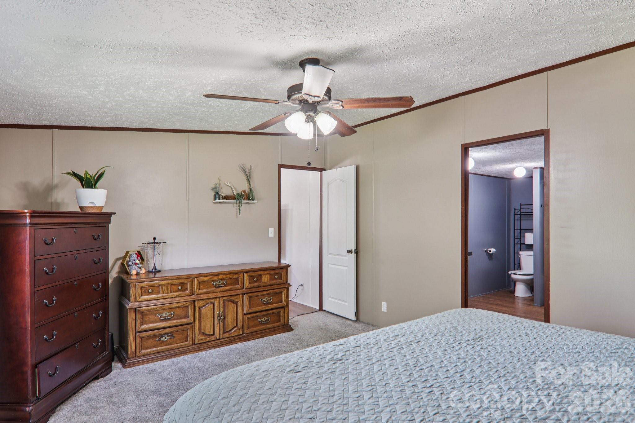 4 Sweet Birch Drive Alexander, NC 28701 - Photo 33 of 48 a bedroom with a dresser and a chandelier
