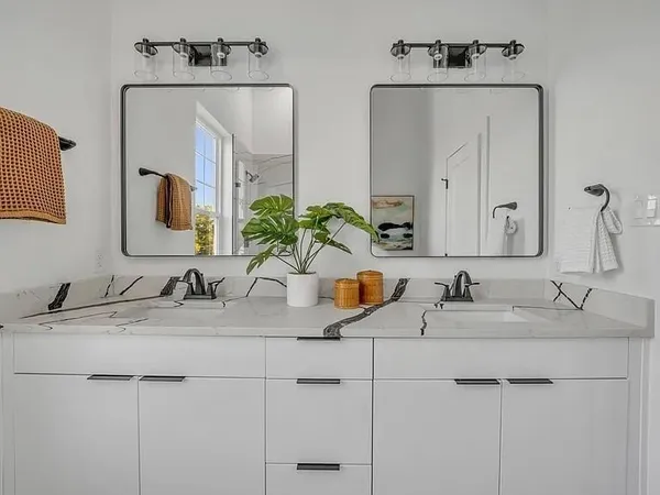 a bathroom with double sink and a mirror