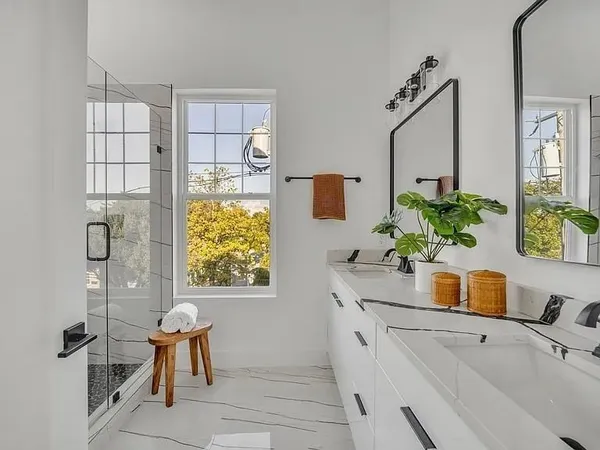 a bathroom with a granite countertop sink a mirror and shower