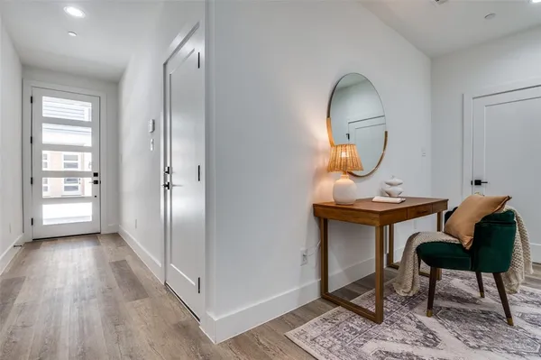 a living room with table chairs wooden floor and a potted plant