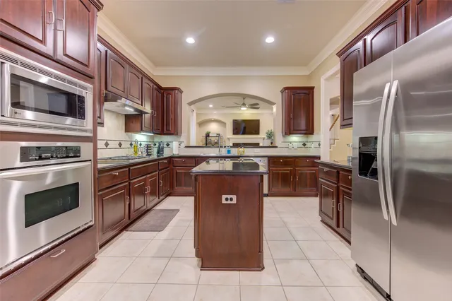 a kitchen with stainless steel appliances granite countertop a stove a sink and a refrigerator