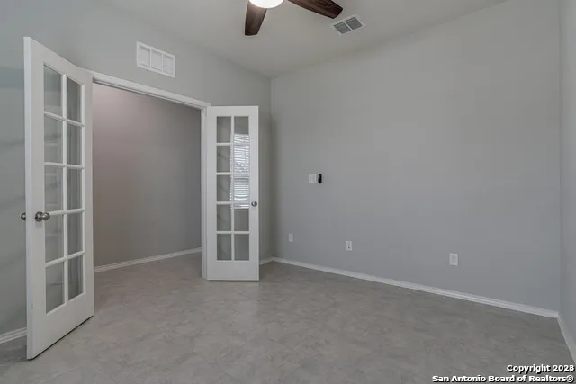 an empty room with closet and a ceiling fan