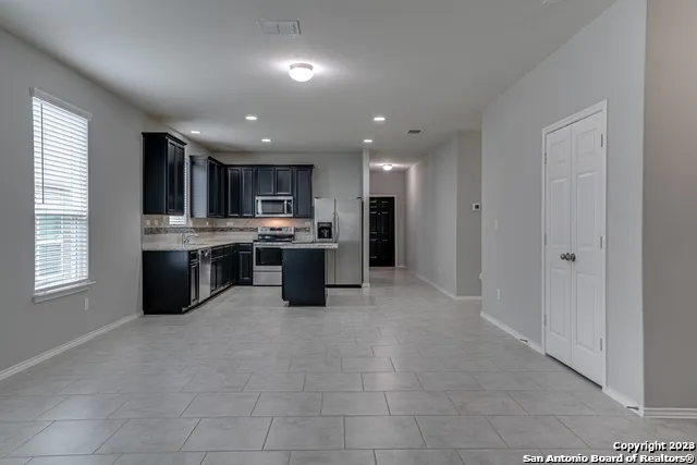 a open kitchen with stainless steel appliances granite countertop a stove top oven a sink dishwasher and a refrigerator