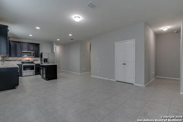 a kitchen with stainless steel appliances granite countertop a refrigerator and a stove top oven