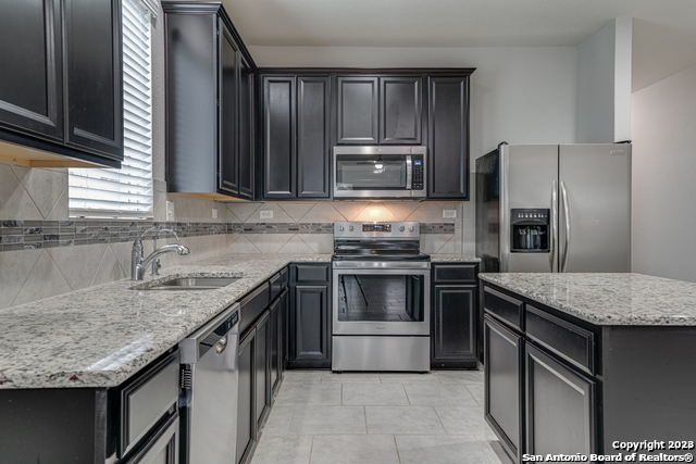 27319 Sterling Silver San Antonio, TX 78260 - Photo 8 of 28 a kitchen with kitchen island granite countertop a sink stove and refrigerator