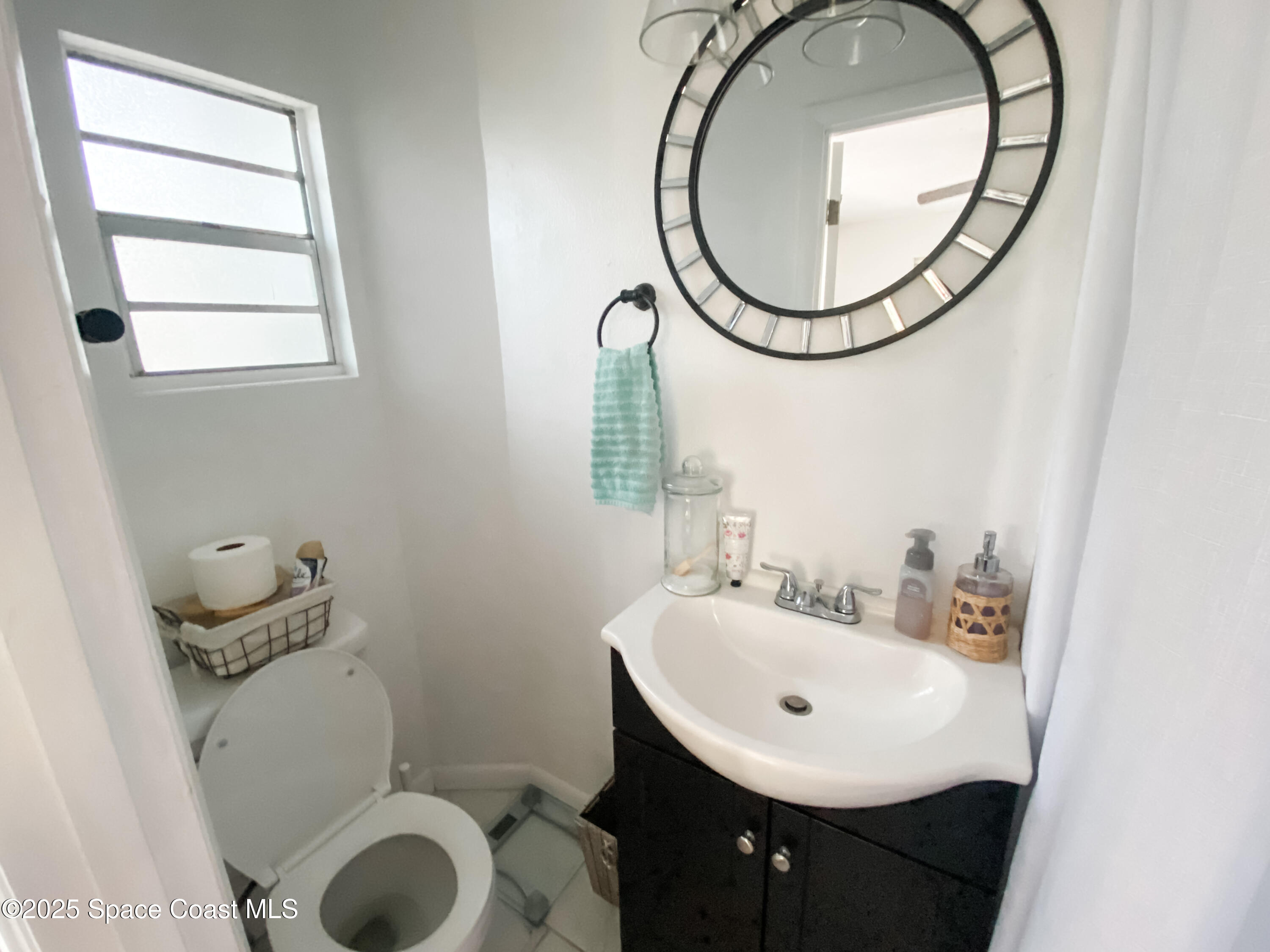 8812 Trevarthon Road Orlando, FL 32817 - Photo 11 of 22 a bathroom with a sink a toilet and a mirror