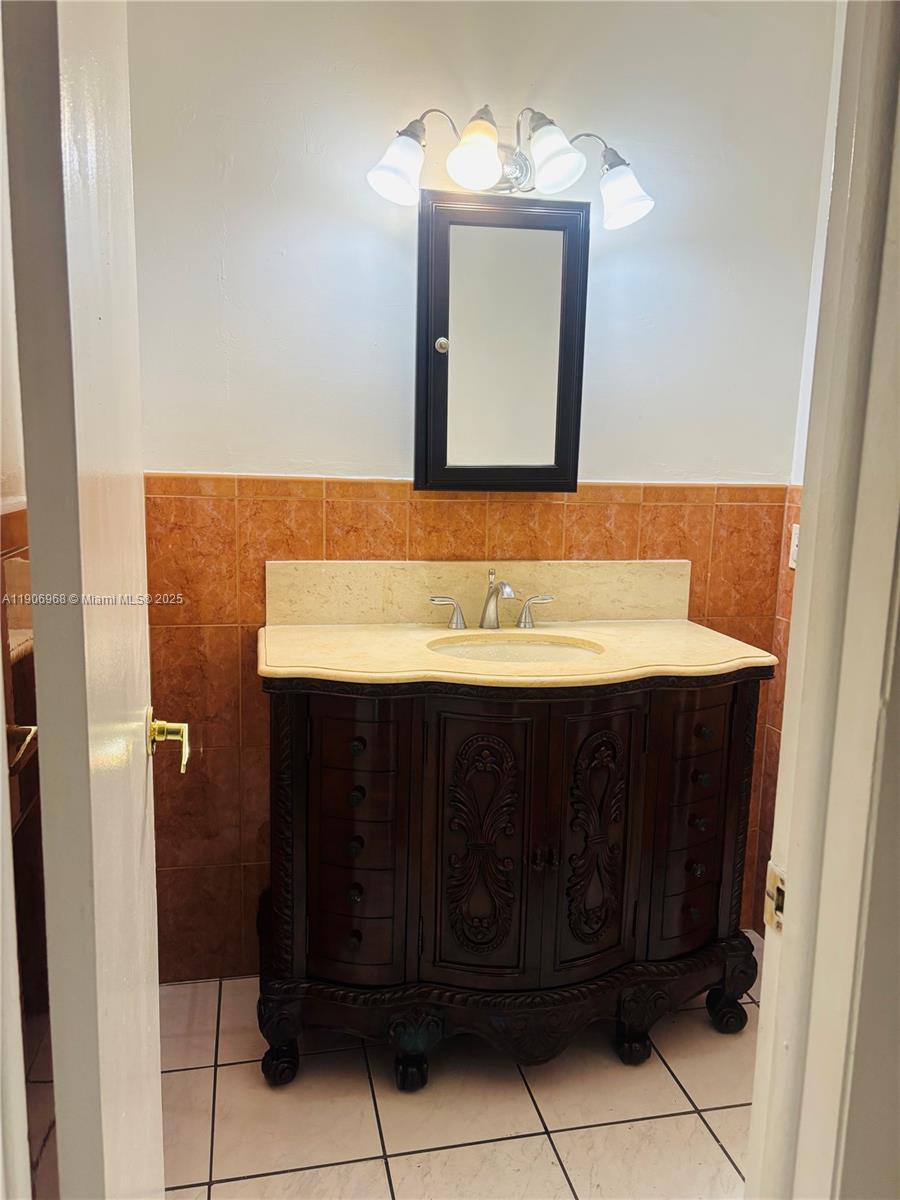 295 Northwest 72nd Avenue, Unit 401 Miami, FL 33126 - Photo 11 of 12 a bathroom with a sink vanity and a mirror