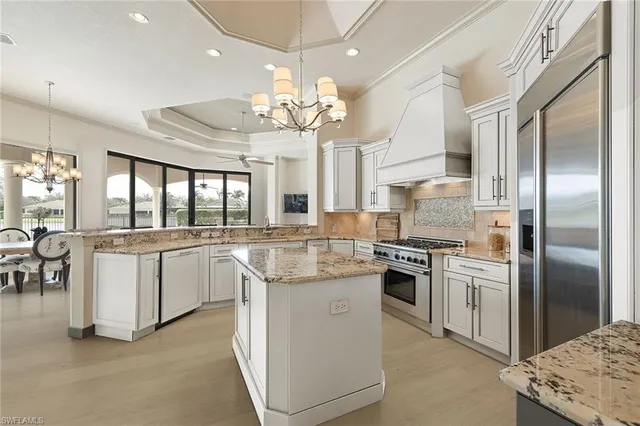 a kitchen with stainless steel appliances granite countertop a white cabinets a stove a sink and a refrigerator