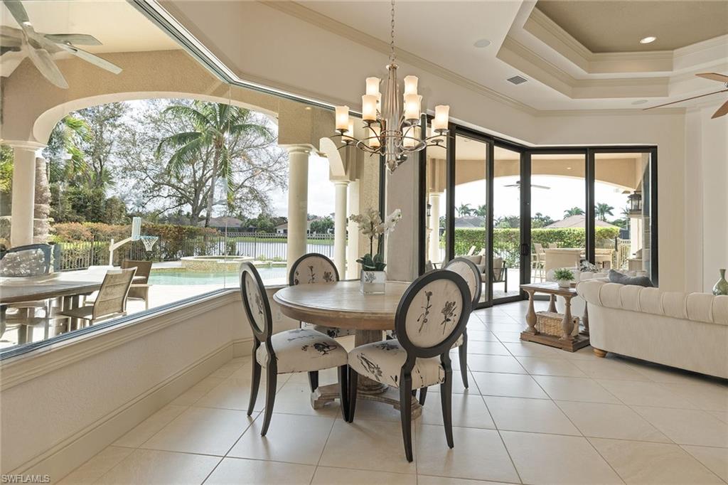 16540 Cellini Lane Naples, FL 34110 - Photo 14 of 50 a dining room with furniture large windows and a chandelier