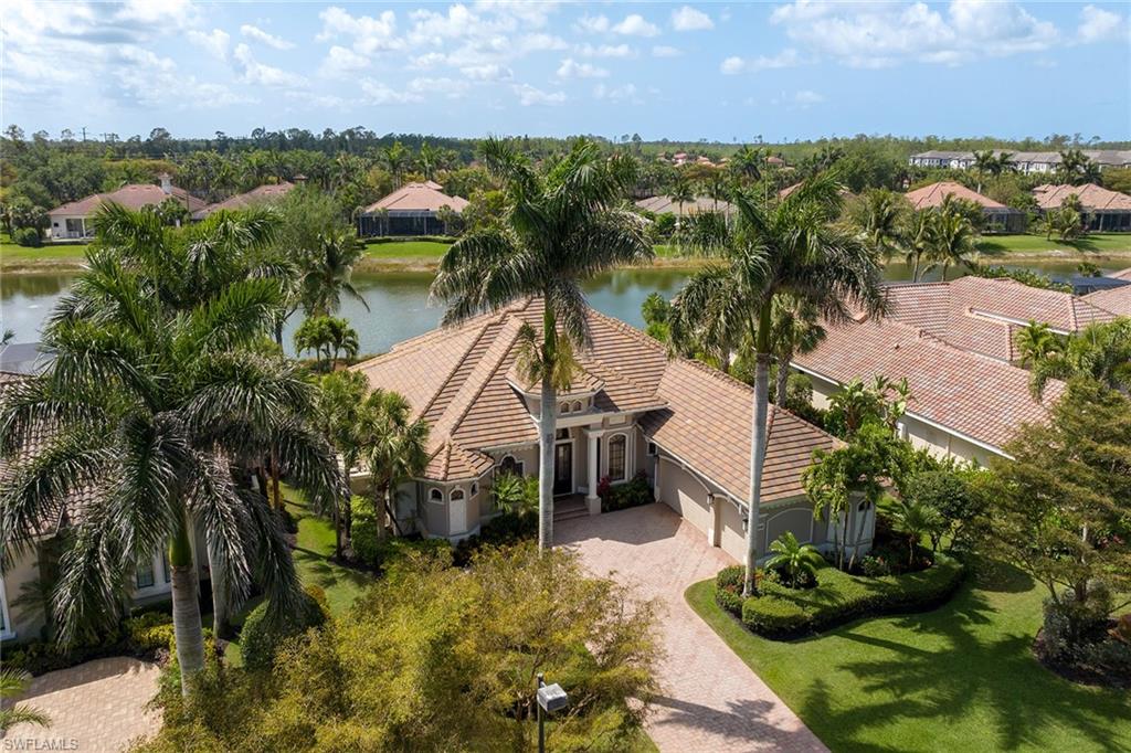16540 Cellini Lane Naples, FL 34110 - Photo 2 of 50 a view of a garden with lawn chairs under an umbrella