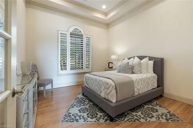 a bedroom with a bed and a table with wooden floor