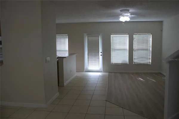 en empty room with windows and ceiling fan