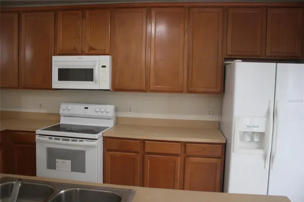 a kitchen with cabinets and white appliances