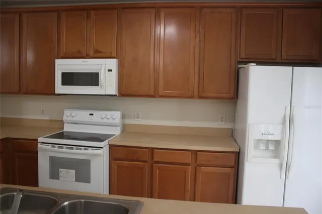 a kitchen with cabinets and white appliances