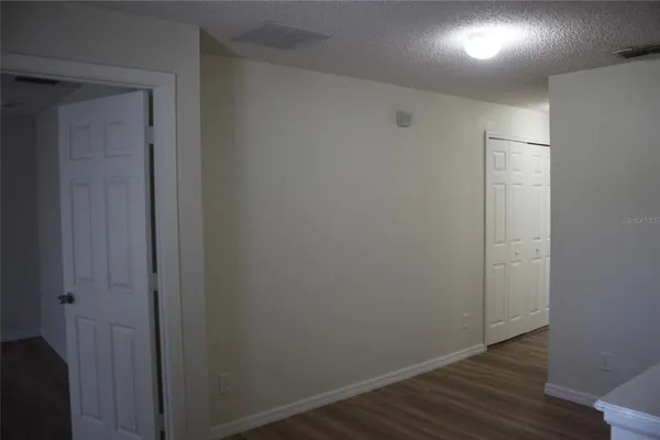 a view of an empty room with wooden floor