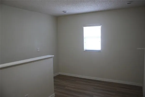 a view of a small space with wooden floor and a window