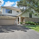 a front view of a house with a garden and yard
