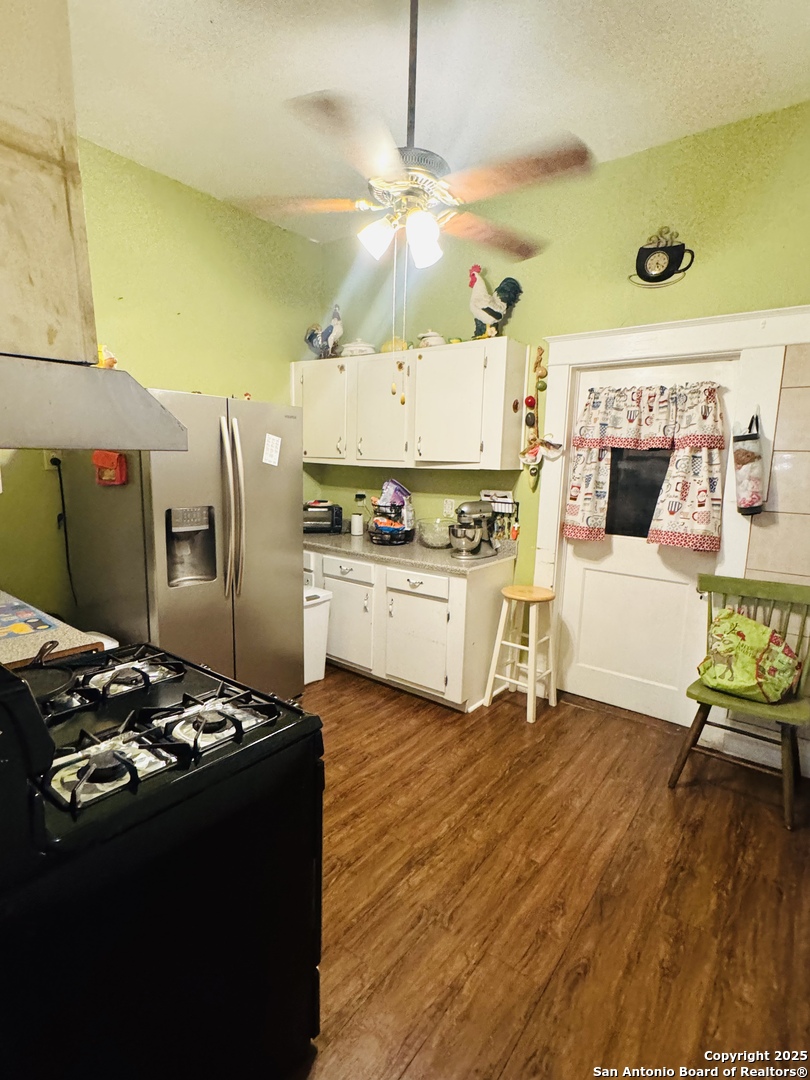 314 Devine Street San Antonio, TX 78210 - Photo 13 of 25 a kitchen with stainless steel appliances wooden floor and a refrigerator