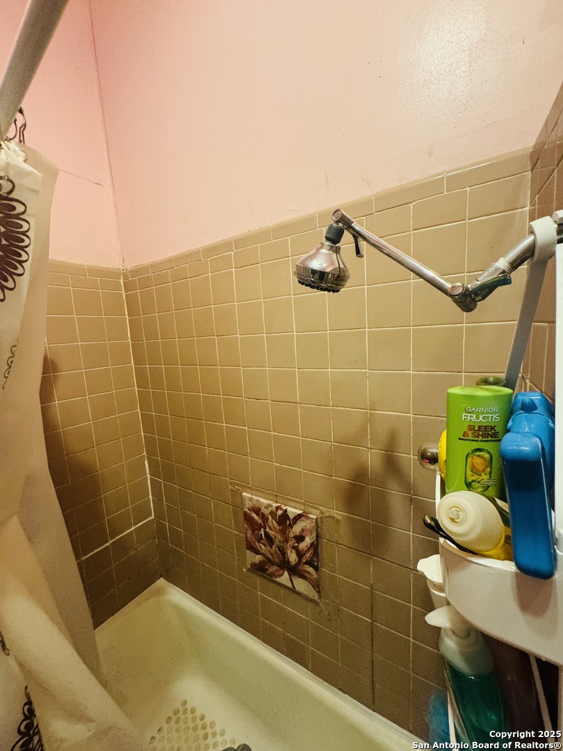 314 Devine Street San Antonio, TX 78210 - Photo 21 of 25 a bathroom with a sink and a blue shower