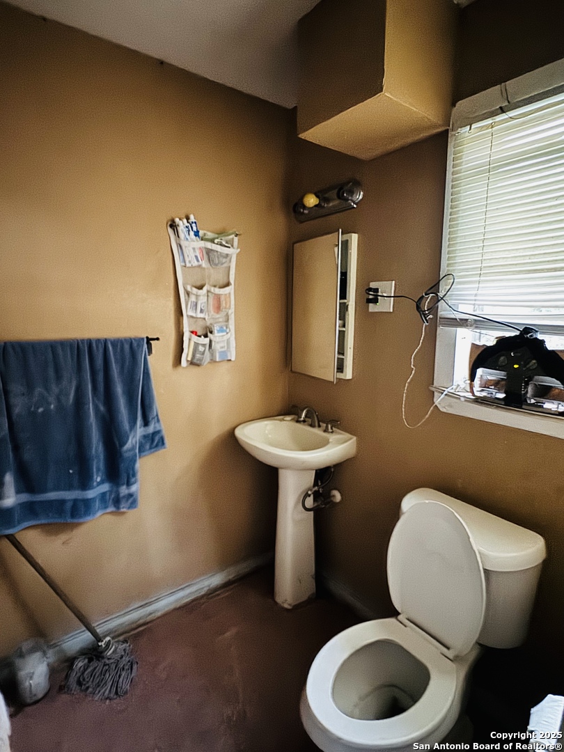 314 Devine Street San Antonio, TX 78210 - Photo 25 of 25 a bathroom with a toilet a sink and mirror