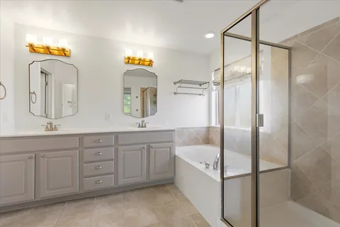 a bathroom with a tub sink and mirror